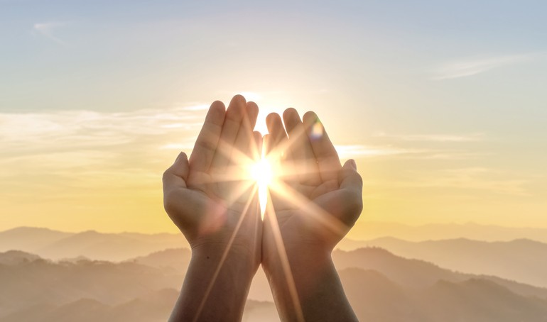 human-hands-praying-to-god-on-mountain-sunset-background